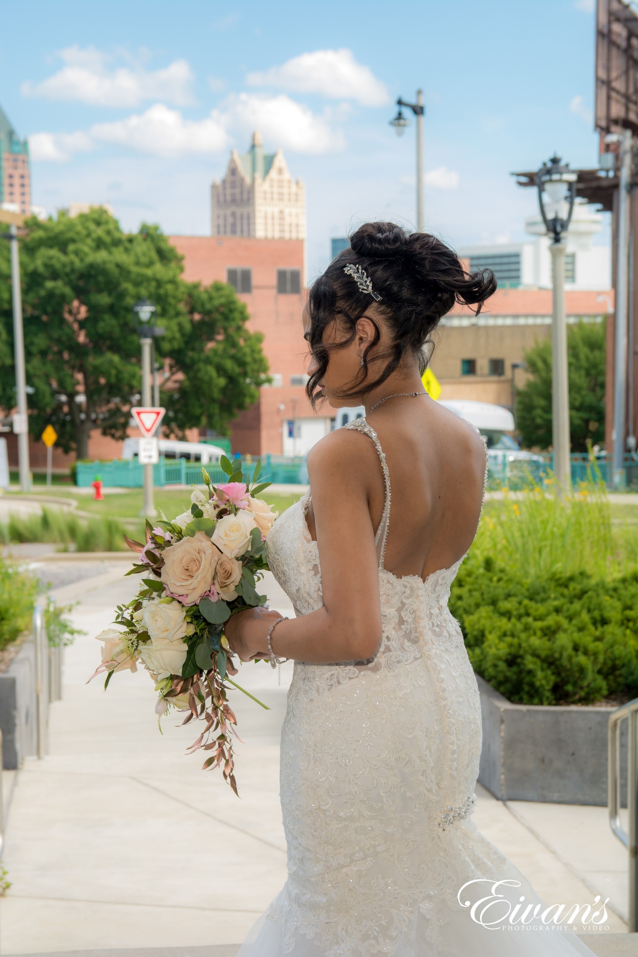 woman in white floral lace wedding dress holding bouquet of flowers