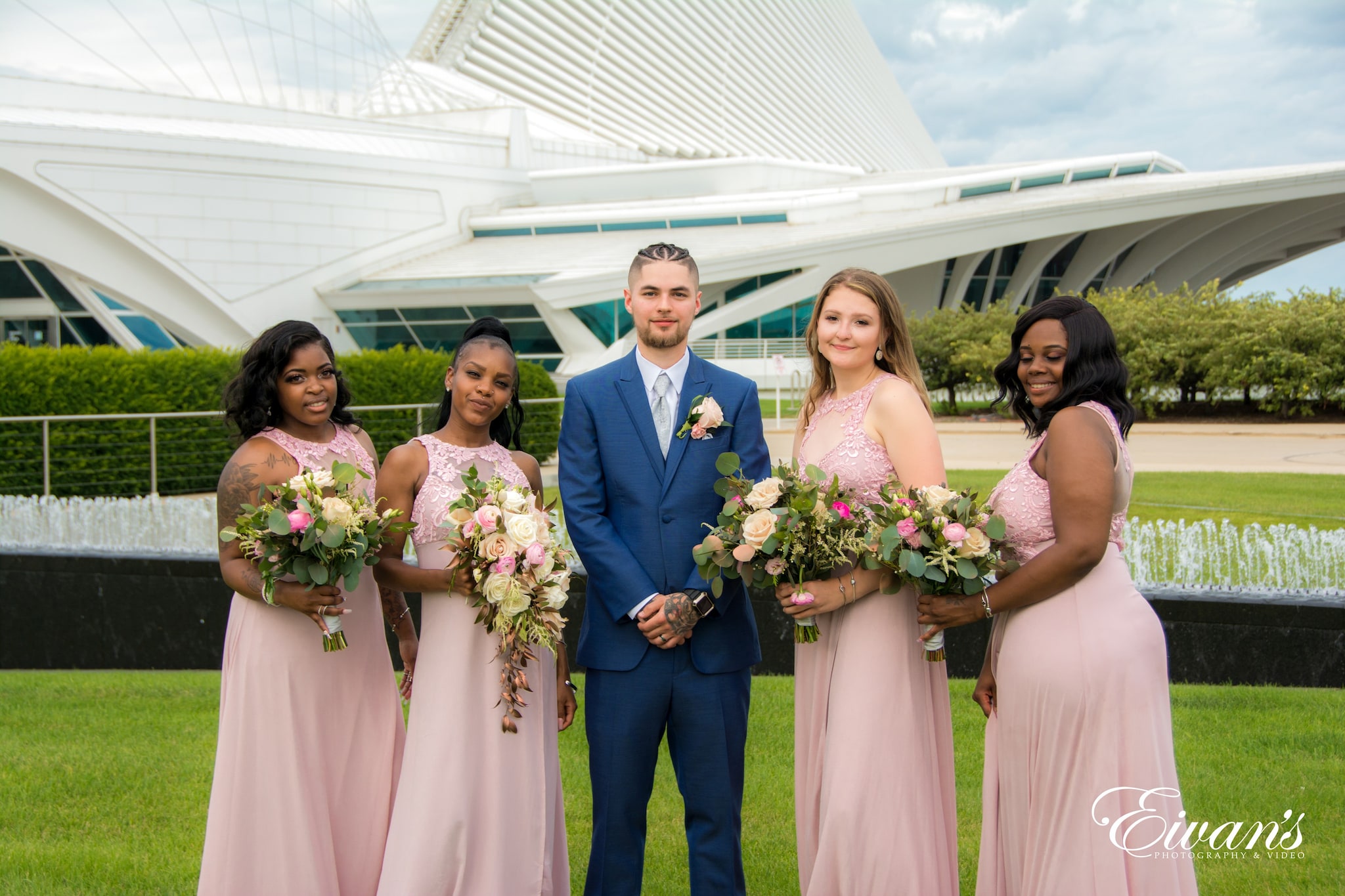 man in blue suit holding bouquet of flowers