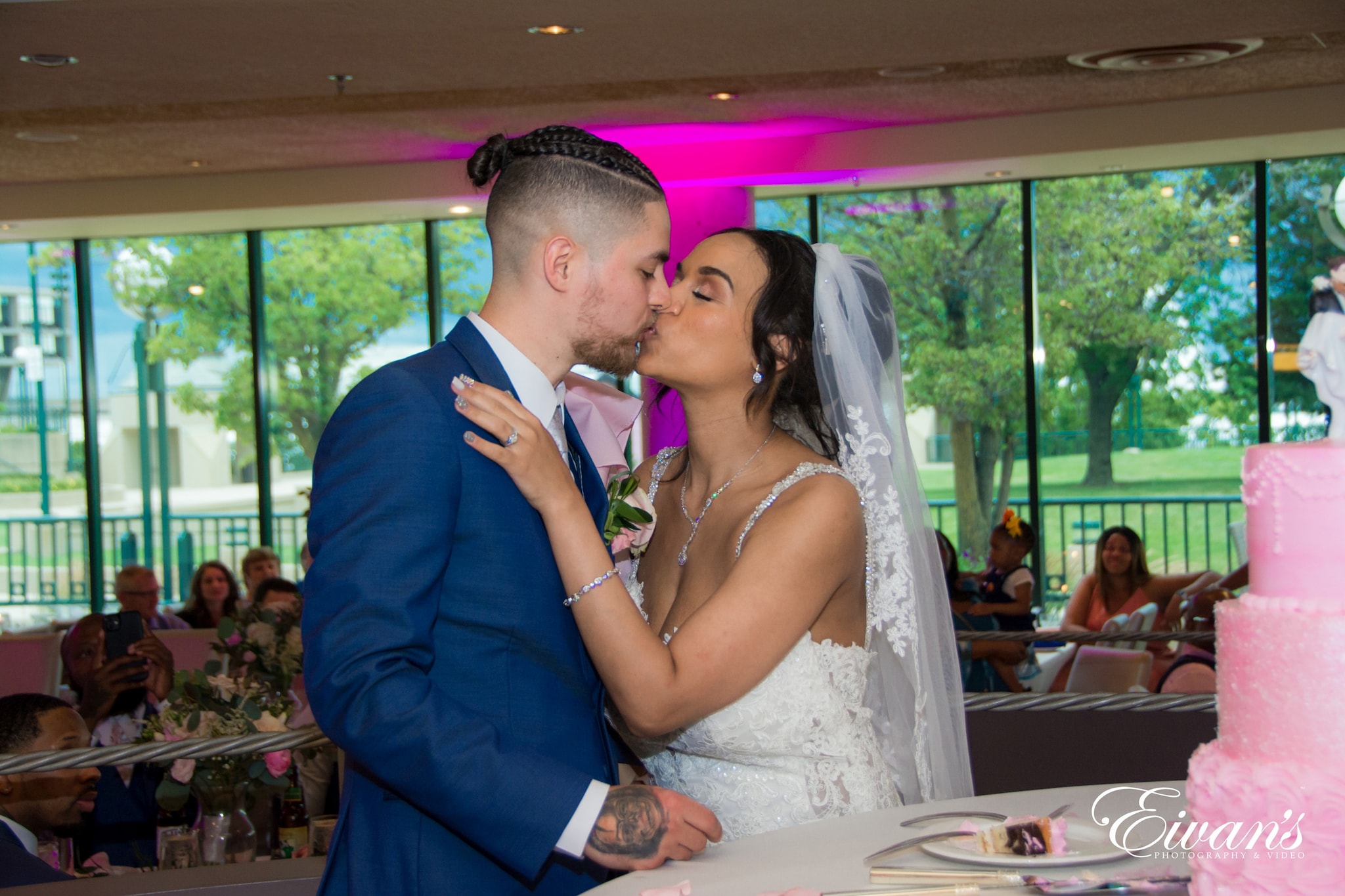 man in blue suit kissing woman in white wedding dress