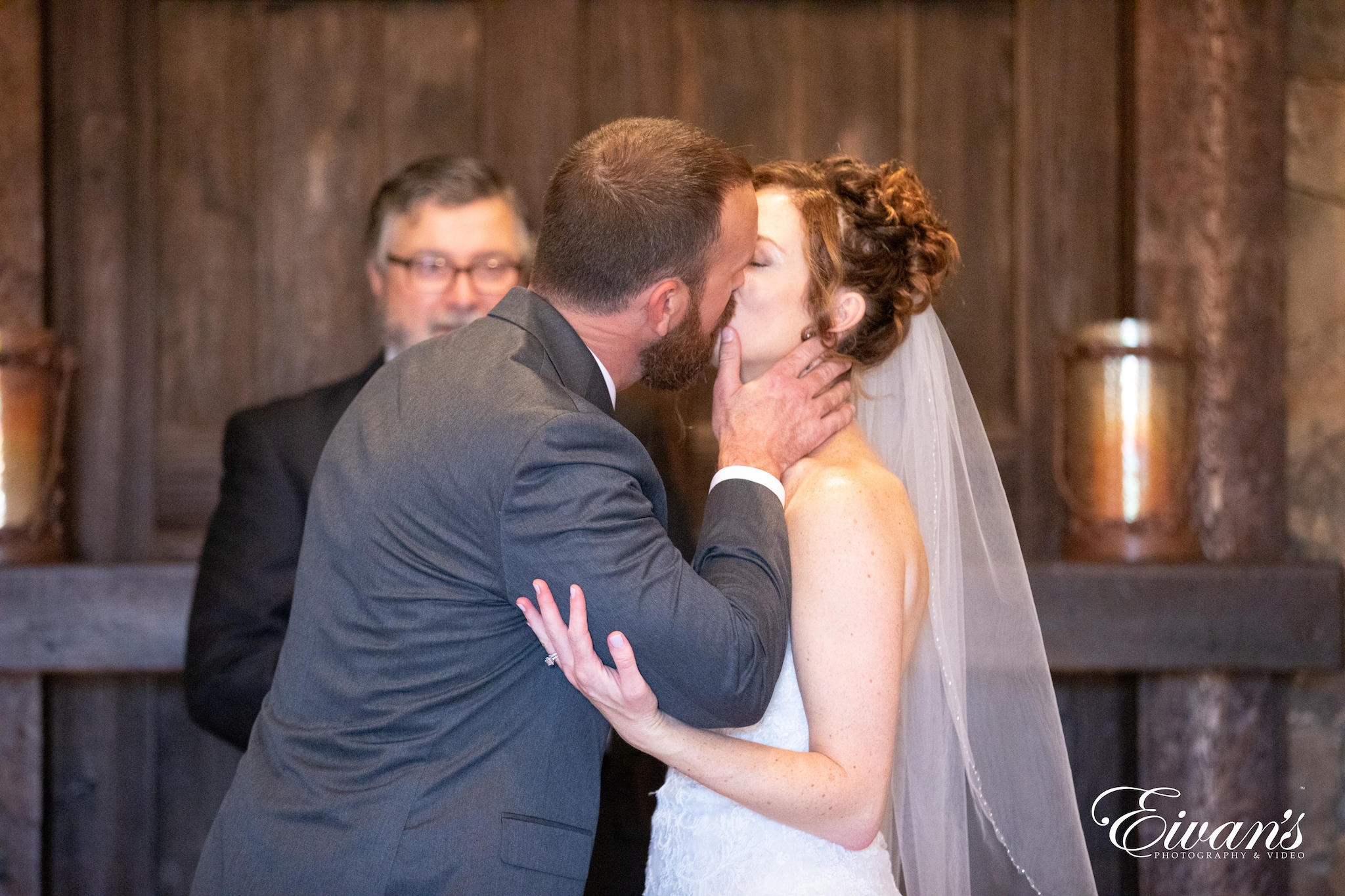 man in black suit kissing woman in white wedding dress