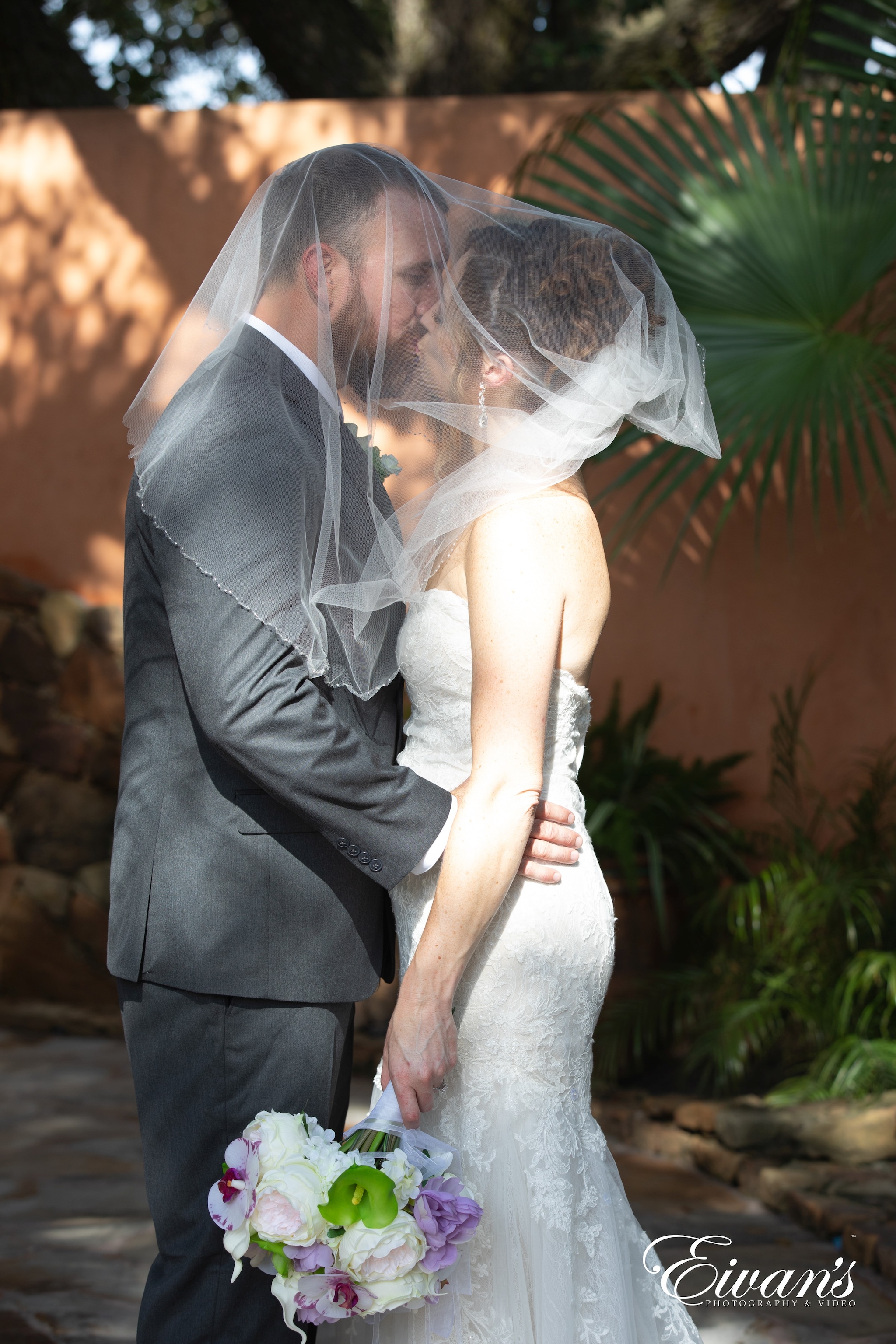 woman in white wedding dress holding man in black suit