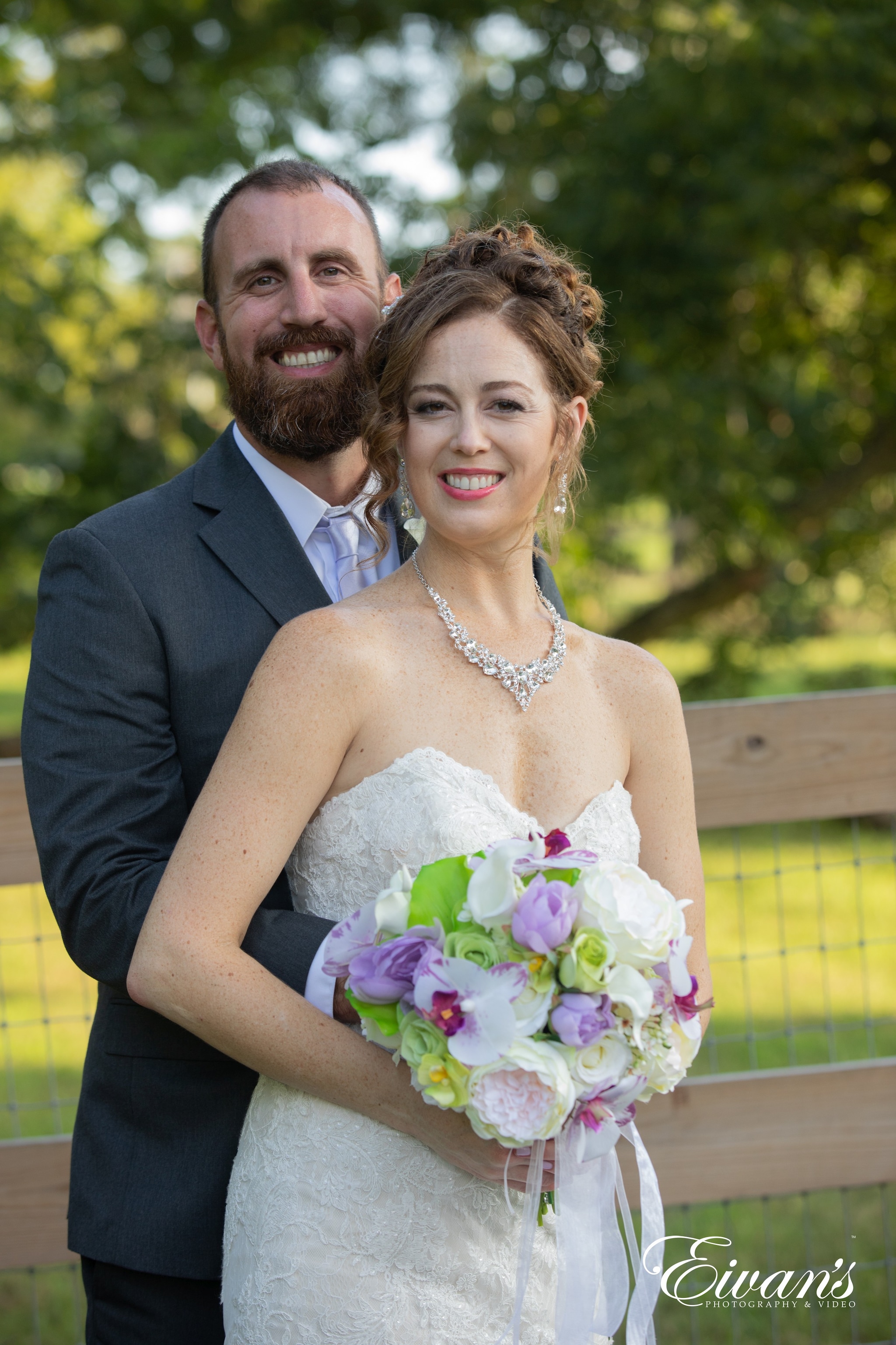 man in black suit jacket hugging woman in white wedding dress
