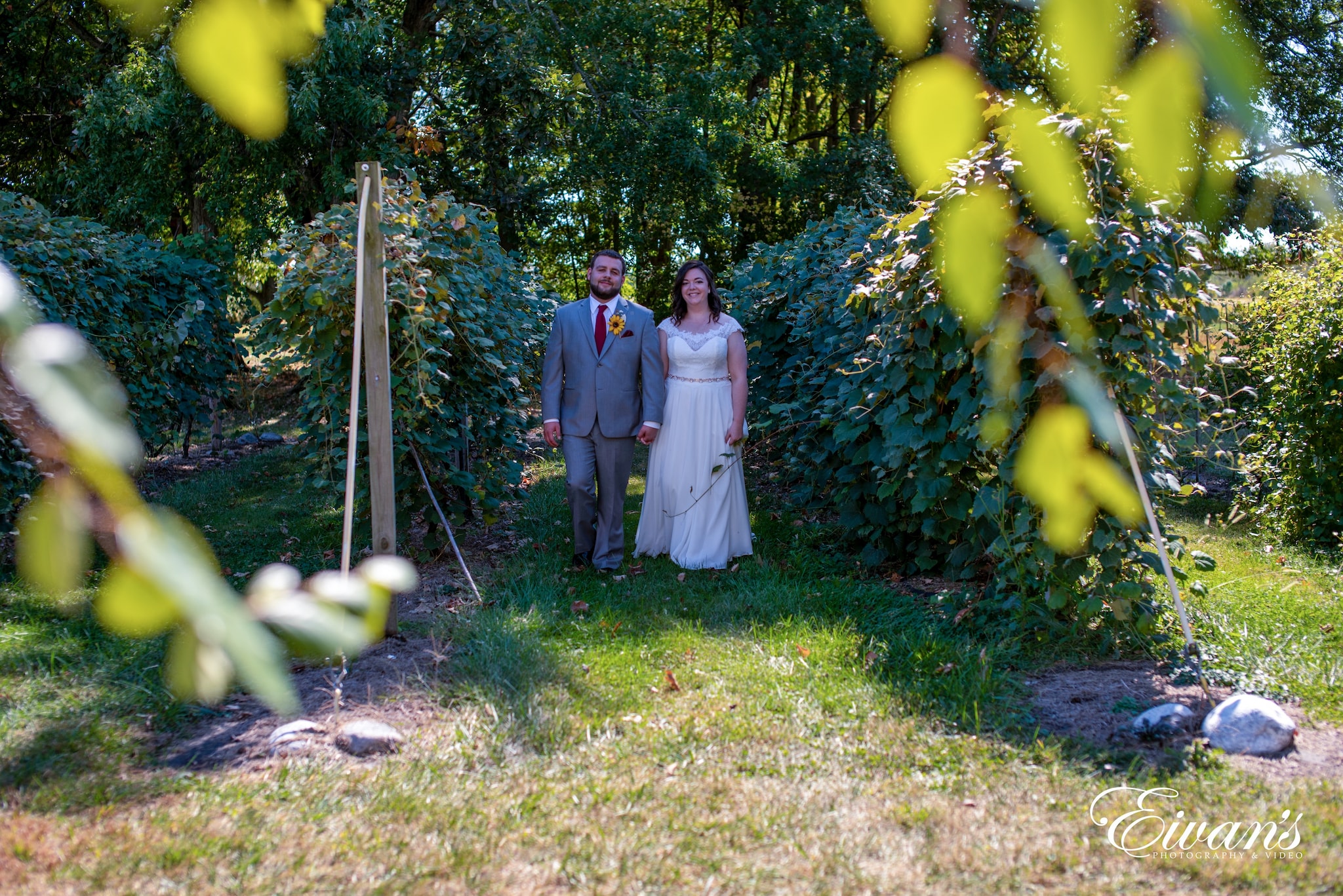 man in black suit standing beside woman in white dress on green grass field during daytime