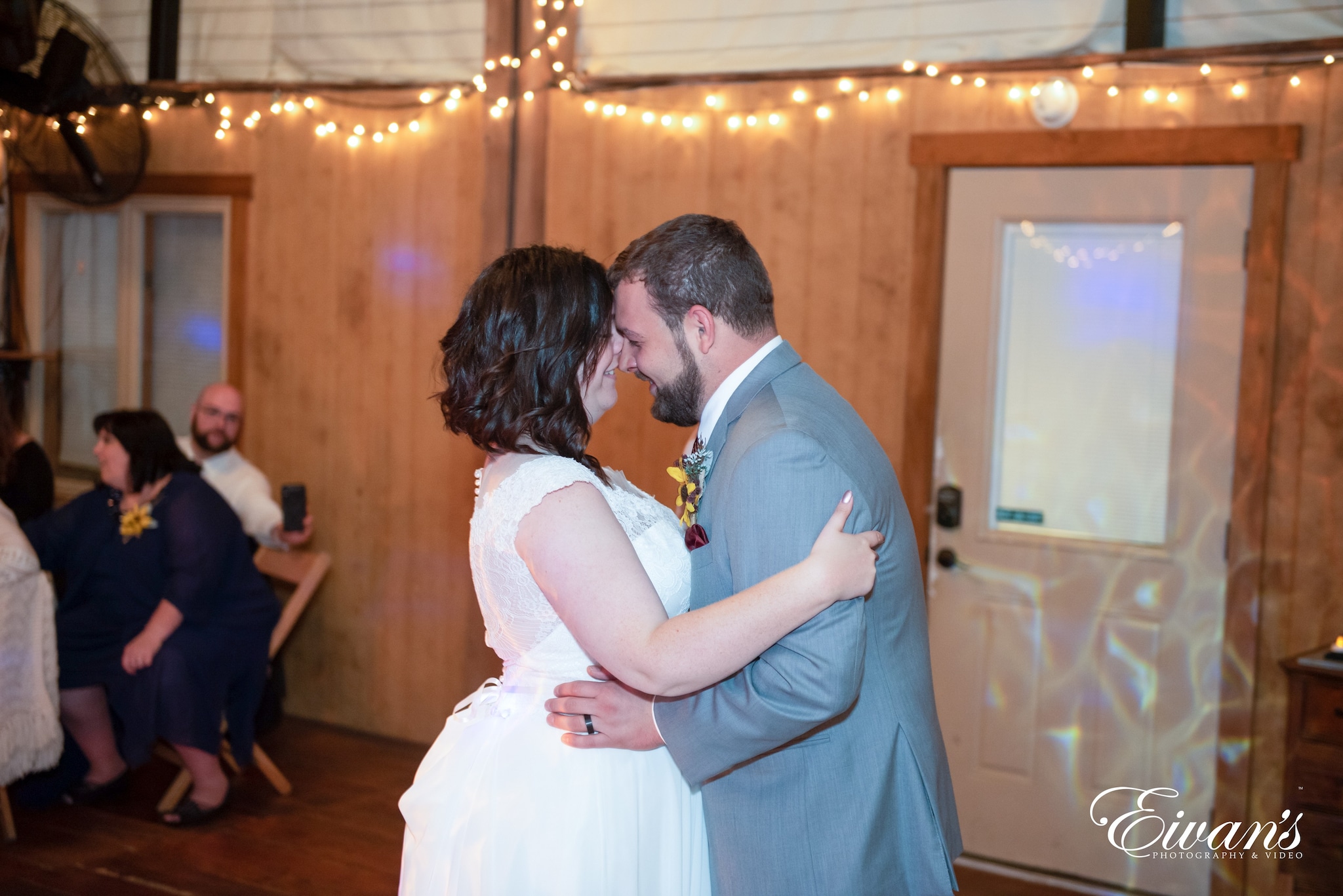 man in gray suit kissing woman in white wedding dress