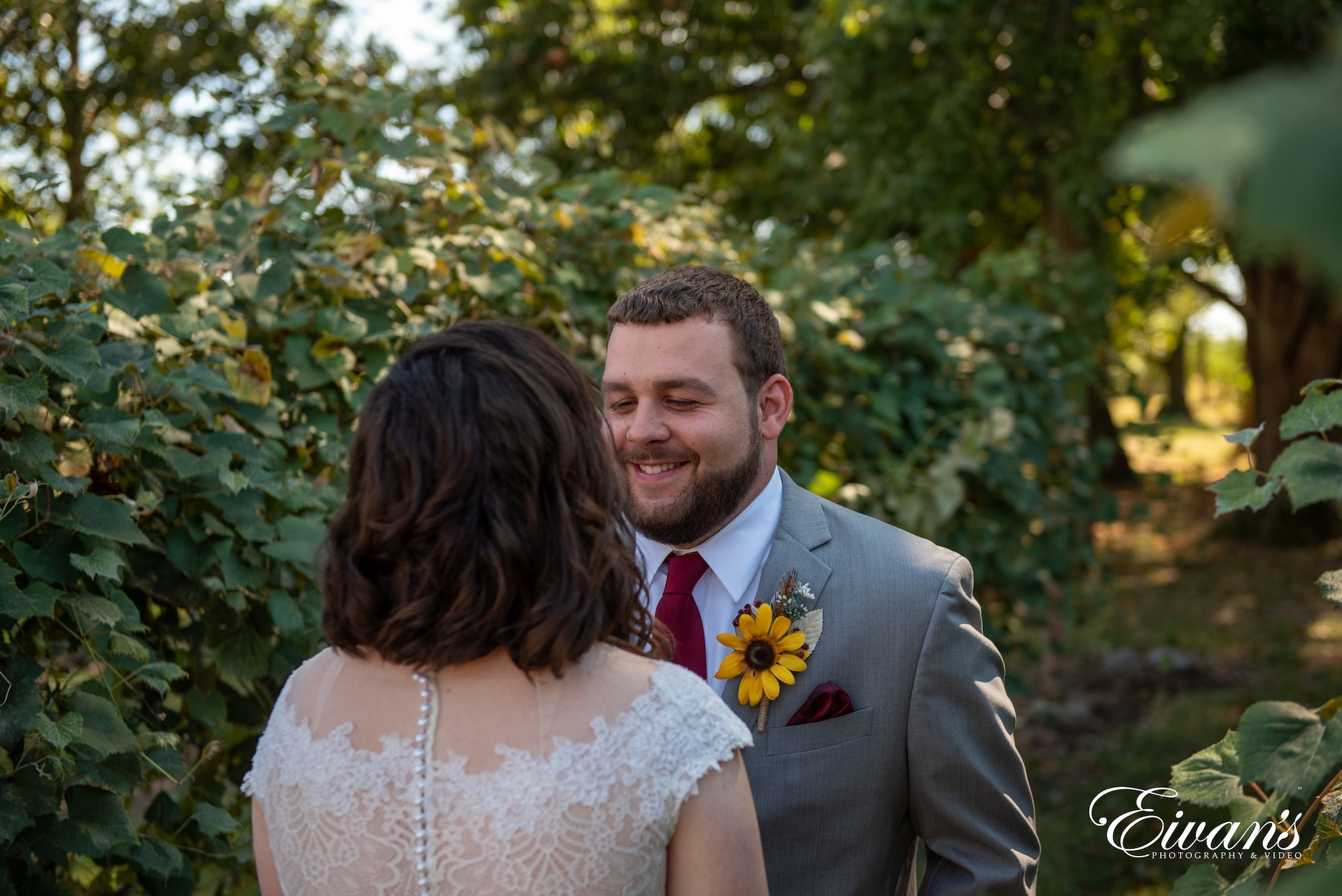 man in black suit jacket kissing woman in white floral wedding dress