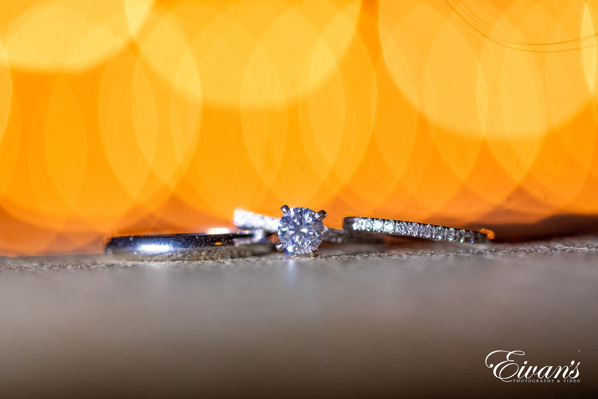 silver diamond ring on orange and white textile
