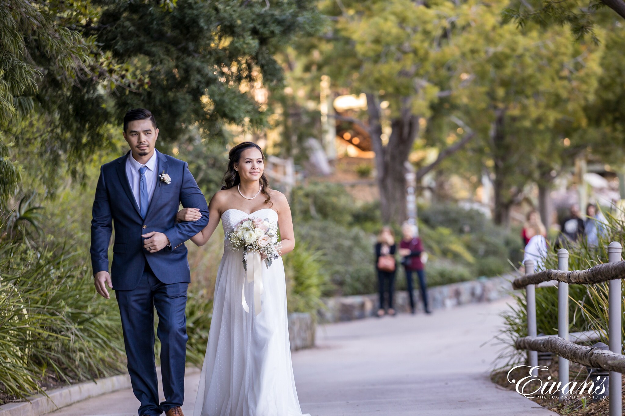 man in black suit and woman in white wedding dress walking on street during daytime