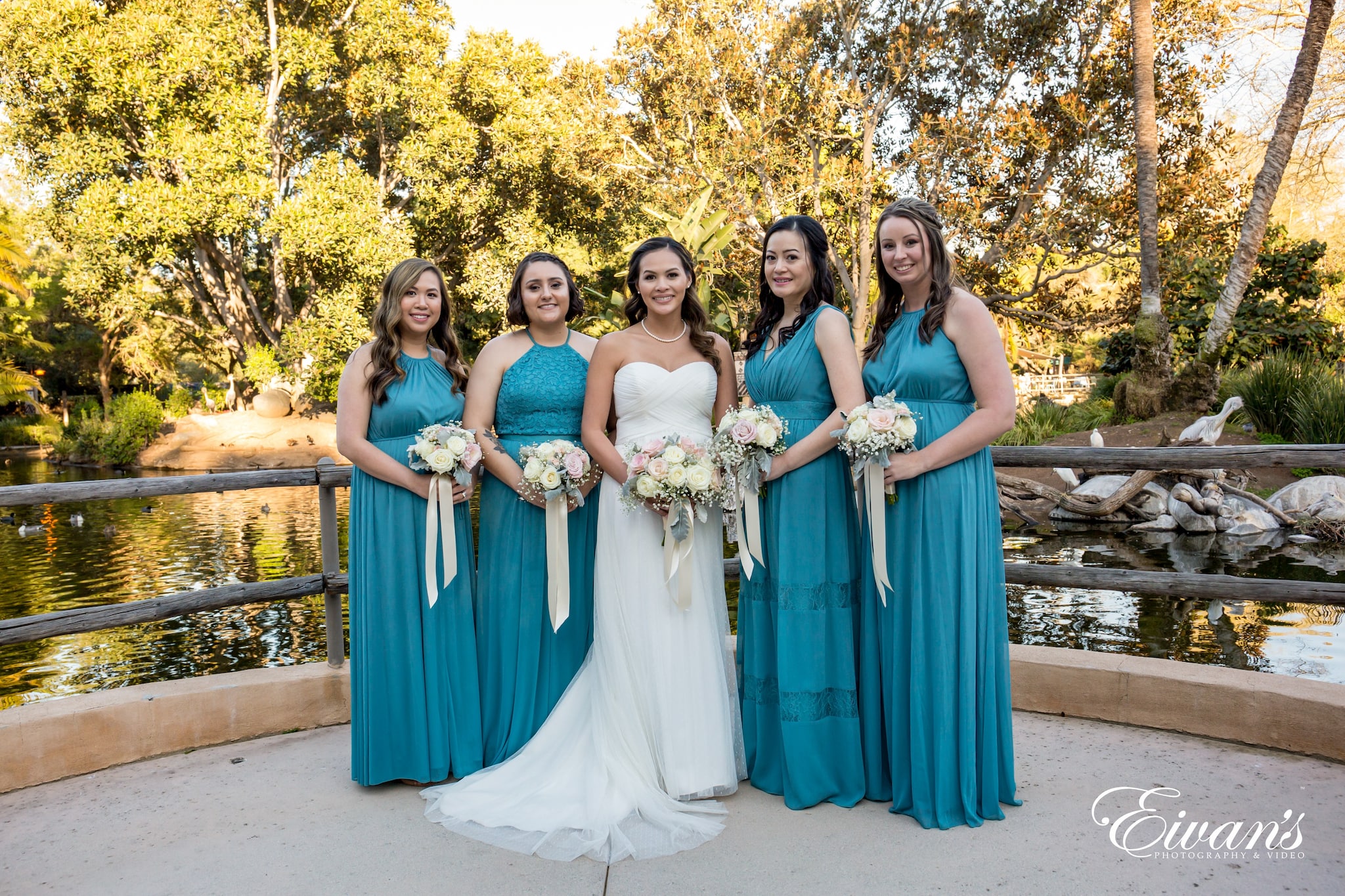 3 women in blue and white dress holding bouquet of flowers