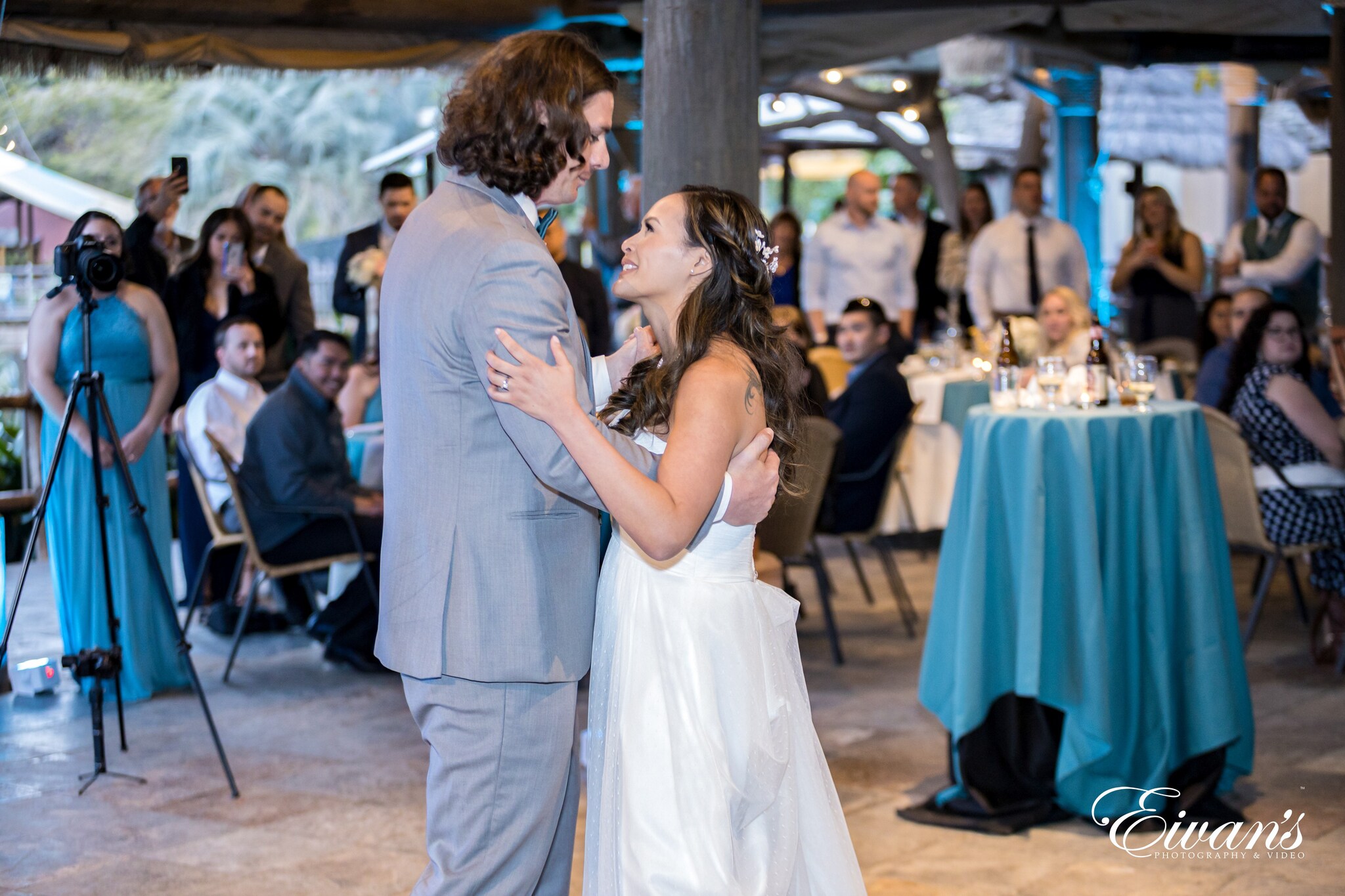 man in gray suit kissing woman in white sleeveless dress